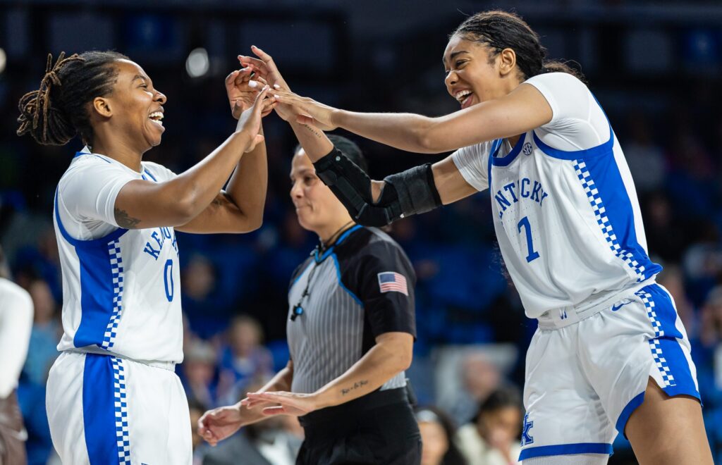 Kentucky guard Jordan Obi and forward Teonni Key high-five and laugh after a play in a 2025/26 NCAA basketball game.