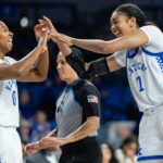 Kentucky guard Jordan Obi and forward Teonni Key high-five and laugh after a play in a 2025/26 NCAA basketball game.