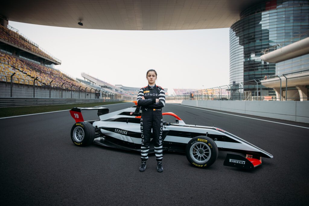 F1 academy driver Natalia Granada poses with her F1 race car at the China Tests wearing a Sephora shirt.