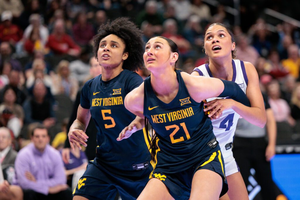 West Virginia forward Riley Makalusky and guard Sydney Shaw box out TCU guard Donovyn Hunter as they all eye a rebound during the 2026 Big 12 women's basketball tournament championship game.