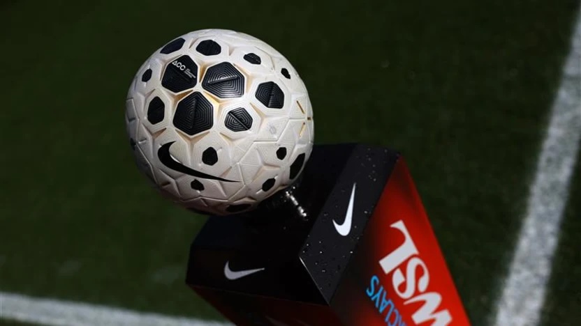The WSL's new official Sportable game ball sits atop a WSL stand on a shadowy football pitch.