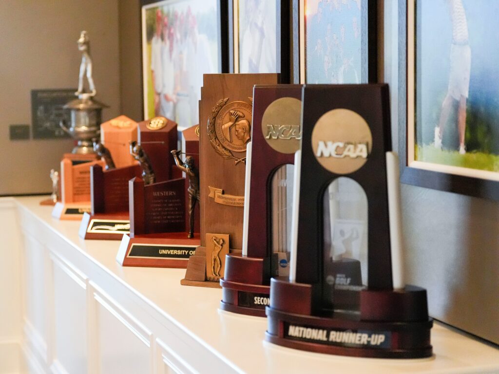 NCAA women's golf championship trophies are displayed from the various championships by both the men and women in the new Crimson Reserve golf training facility at the University of Alabama Friday, Oct. 11, 2024.