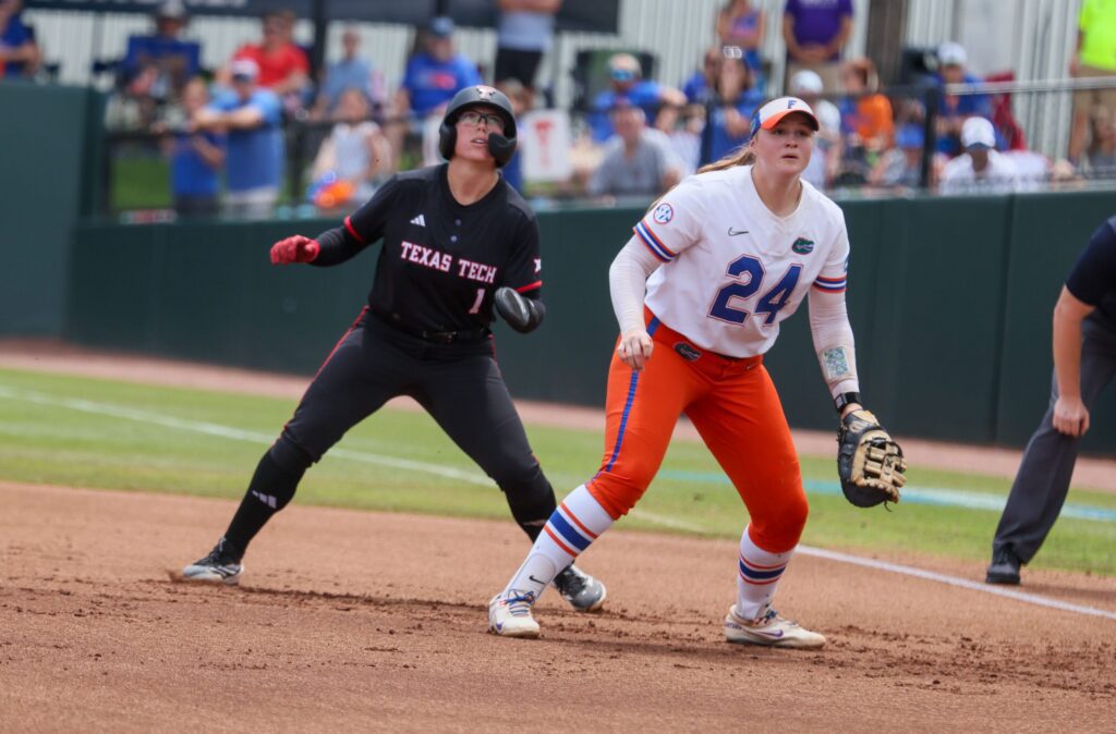 Florida infielder Madison Walker (24) looks for the throw while Texas Tech second baseman Mia Williams (1) contemplates a steal during game 3 of the super regional of the NCAA Division 1 softball championship.