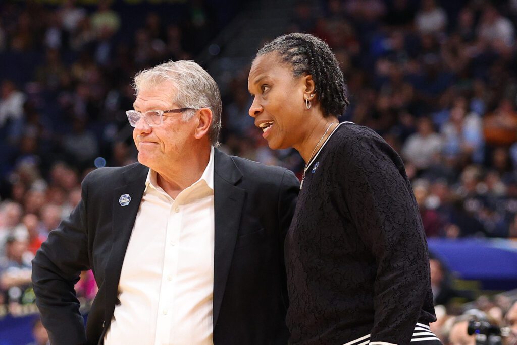UConn Huskies assistant coach Jamelle Elliott speaks with UConn Huskies head coach Geno Auriemma during the 2025 NCAA Div I Women's Championship Final Four game between UConn Huskies and UCLA Bruins.