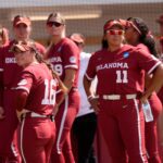 Oklahoma's Abby Dayton (16) and Kierston Deal (11) watch Mississippi State celebrate following Game 3 of the NCAA softball Norman Super Regional between the University of Oklahoma Sooners and the Mississippi State Bulldogs.