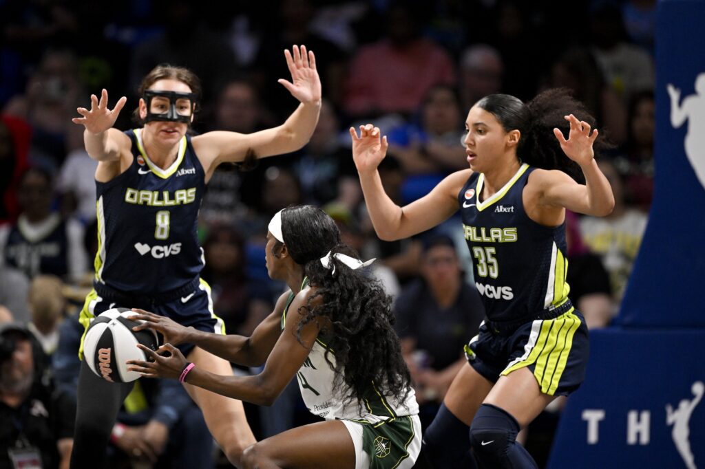 Seattle Storm guard Flau'jae Johnson (4) looks to move the ball past Dallas Wings forward Alanna Smith (8) and guard Azzi Fudd (35) during the second half at College Park Center.