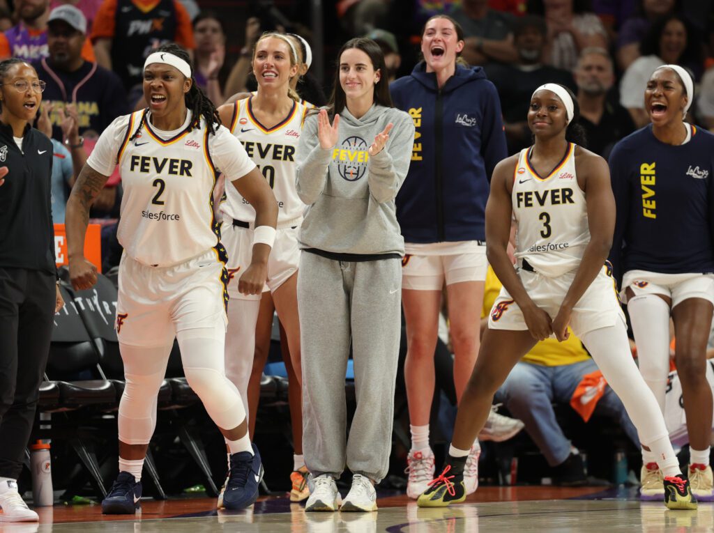 Indiana Fever guard Caitlin Clark (center) celebrates with forward Myisha Hines-Allen (2) and guard Raven Johnson (3) against the Phoenix Mercury at Mortgage Matchup Center.