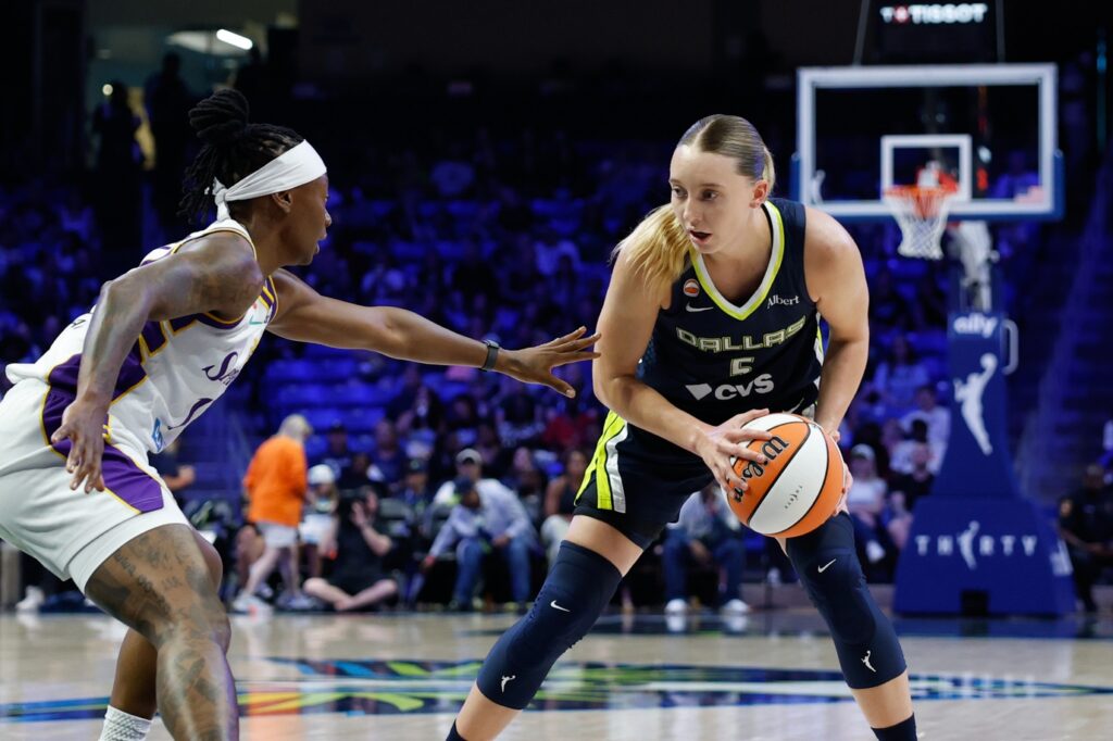 Dallas Wings guard Paige Bueckers (5) controls the ball as Los Angeles Sparks guard Erica Wheeler (17) defends during the first half at College Park Center.