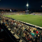 The Boston Legacy play an NWSL game at Centreville Bank Stadium in Rhode Island, in view of the stands and the scoreboard.