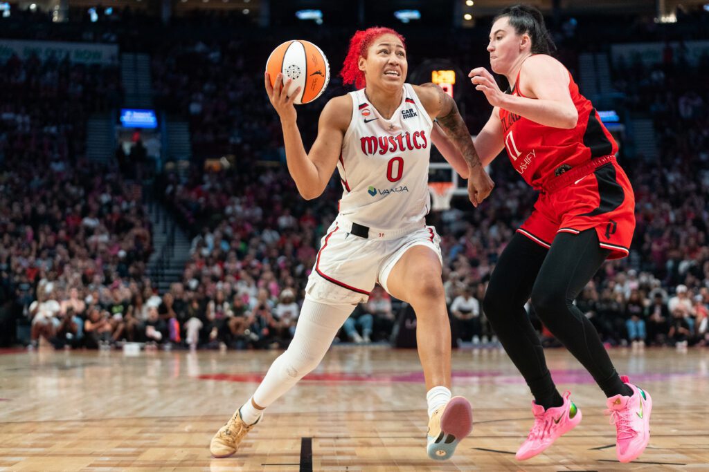 Shakira Austin #0 of the Washington Mystics drives to the basket against Megan DiLeo #17 of the Portland Fire during the second half of the game at Moda Center.