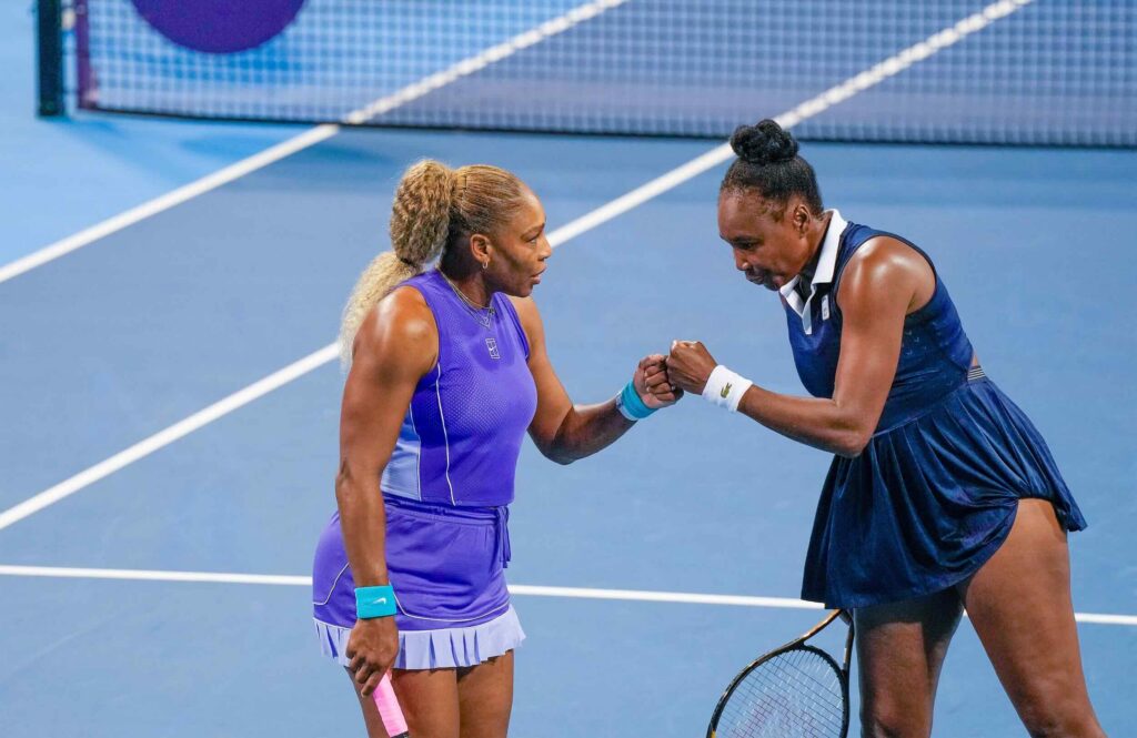 Serena Williams and her sister, Venus Williams, bump fists during a doubles match at the Cincinnati Open at the Lindner Family Tennis Center in Mason on Aug. 17, 2026. The sisters fell to Marta Kostyuk and Peyton Stearns, 6-2, 1-6, 10-8.