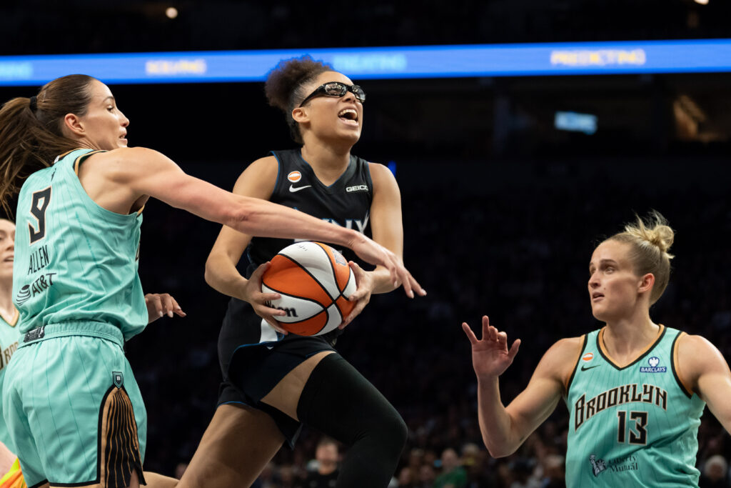 Minnesota Lynx guard Olivia Miles (5) drives to the basket past New York Liberty forward-guard Rebecca Allen (9) and New York Liberty forward Leonie Fiebich (13) in the second half at Target Center.