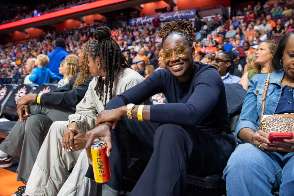 Former Connecticut Sun center Tina Charles poses for a photo with a can of SUNSET Hazy IPA beer during the WNBA game between the Chicago Sky and the Connecticut Sun.