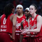 Indiana Fever guard Caitlin Clark (22) huddles up with her team during a game against the Washington Mystics.