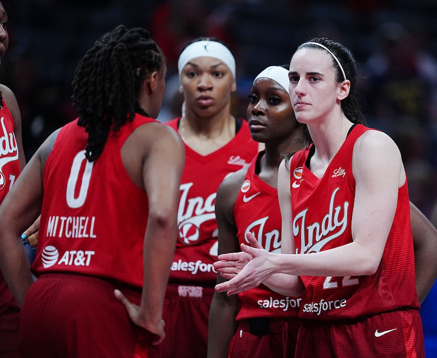Indiana Fever guard Caitlin Clark (22) huddles up with her team during a game against the Washington Mystics.