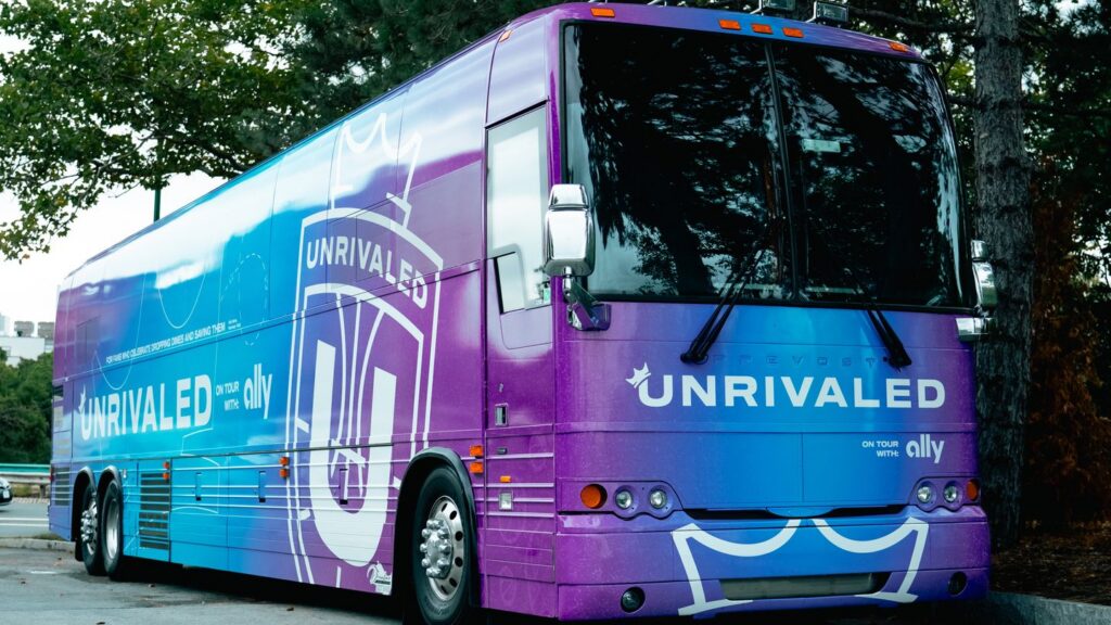 Photo of blue and purple Unrivaled Basketball tour bus.