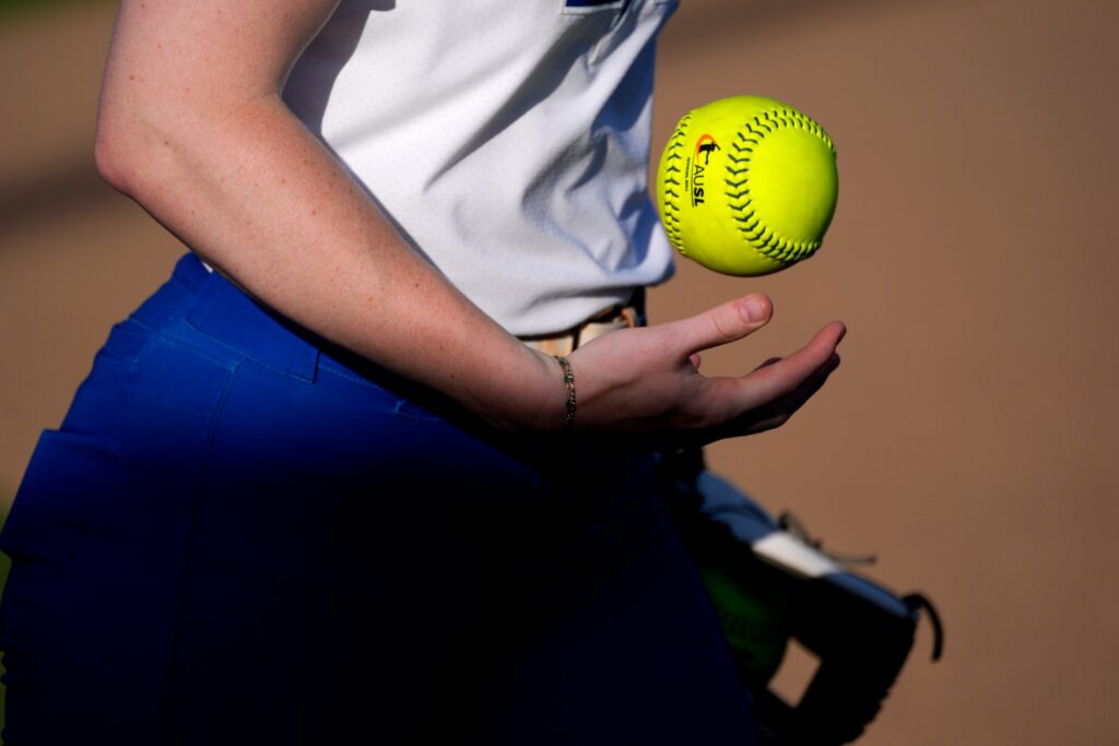 A player flips a softball between innings during an AUSL softball game between the Oklahoma City Spark and the Texas Volts at Oklahoma Christian University, Tuesday, June 9, 2026.