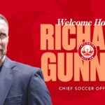 Red graphic featuring a head shot of new Atlanta City Chief Soccer Officer Richard Gunney, as well as graphic text of his name, and the Atlanta City logo.