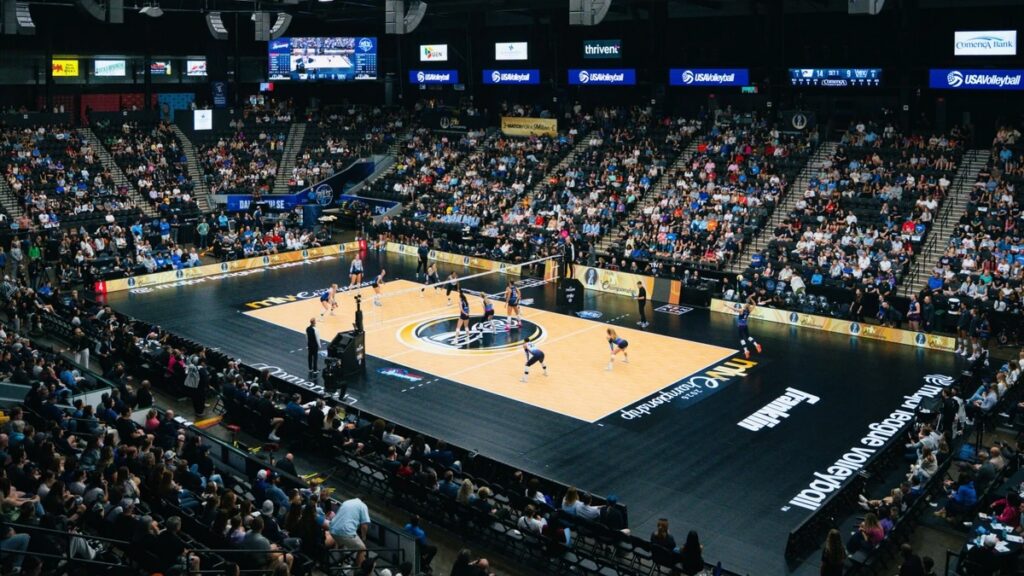 A zoomed out shot of a Major League Volleyball game, with strong attendance at a volleyball arena.
