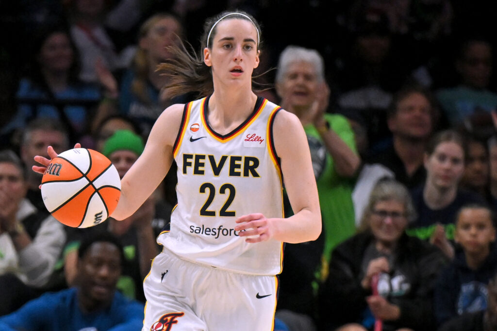 Indiana Fever guard Caitlin Clark (22) brings the ball up court during the first half of a WNBA game between the Minnesota Lynx and Indiana Fever.