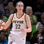 Indiana Fever guard Caitlin Clark (22) brings the ball up court during the first half of a WNBA game between the Minnesota Lynx and Indiana Fever.
