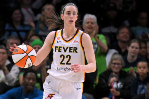 Indiana Fever guard Caitlin Clark (22) brings the ball up court during the first half of a WNBA game between the Minnesota Lynx and Indiana Fever.