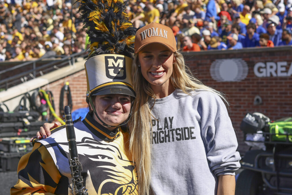 WNBA star and Missouri Tigers alumni Sophie Cunningham poses for a picture with a marching band member before an SEC football game between the Florida Gators and Missouri Tigers.