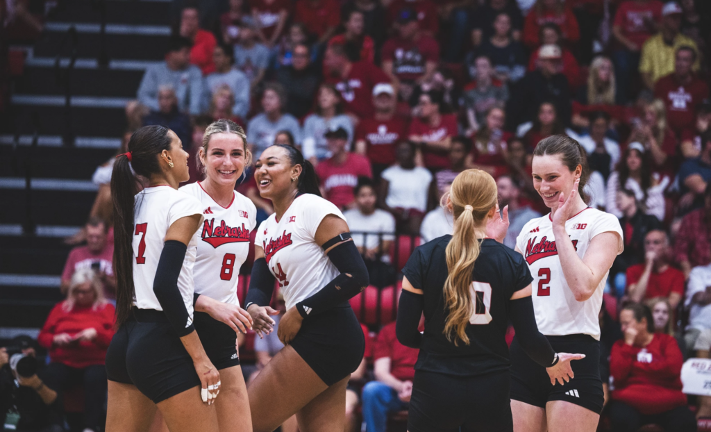 Nebraska women's college volleyball team celebrate point.