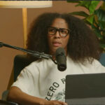 Former Indiana Fever player Sydney Colson records her podcast against a brown background holding an iPad.