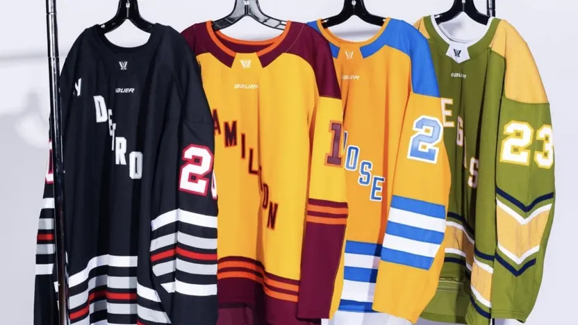 San Jose, Las Vegas, Detroit, and Hamilton PWHL jerseys hang alongside each other on a clothing rack.