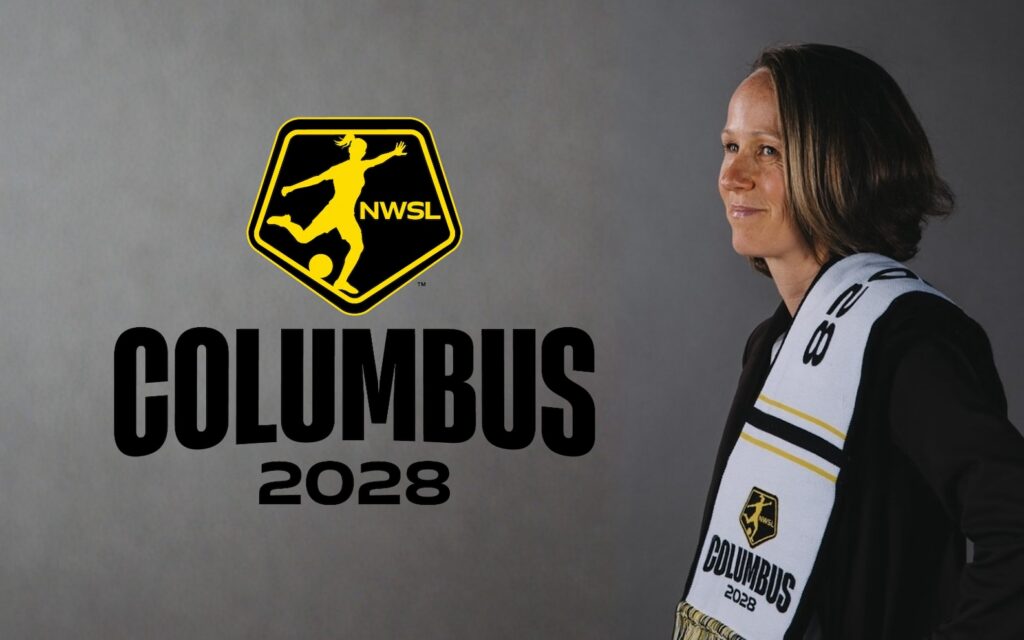 Lucy Rushton poses with a NWSL Columbus 2028 scarf, next to a yellow NWSL logo above "COLUMBUS 2028" text.
